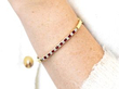 wearing a ruby and gold bangle