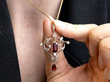 holding a garnet pendant
