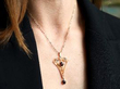 wearing garnet and pearl pendant in gold