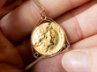 antique gold coin pendant in hand