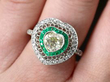 heart shaped emerald diamond ring on finger