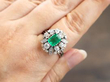 emerald and diamond ring on finger