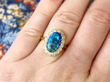 black opal and yellow gold ring on finger