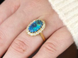 opal and gold ring being worn