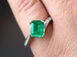 emerald and diamond ring on finger
