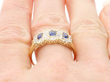 yellow gold sapphire diamond cluster ring on finger