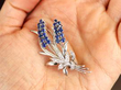 Holding a Sapphire Floral Brooch with Diamonds