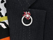 wearing ruby and diamond circular floral brooch