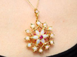 Opal and Ruby Floral Pendant in Gold being worn
