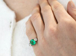Emerald Trilogy Engagement Ring in Yellow Gold on finger