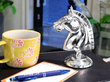 silver horse paperweight on table