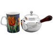 silver teapot next to a mug