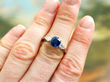 Platinum Sapphire Ring with Pear Side Diamonds on finger