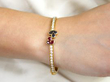 wearing ruby sapphire diamond yellow gold bangle