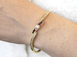 wearing a ruby and gold bangle