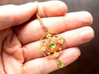 holding an antique peridot pendant in gold