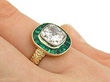 emerald and diamond halo ring on hand