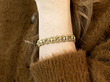 wearing a pearl and gold bracelet