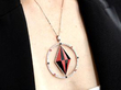 wearing a coral, diamond and onyx pendant