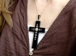 wearing holding a black onyx cross pendant