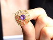 holding amethyst and peridot brooch