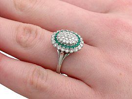 wearing a vintage diamond and emerald cocktail ring on hand