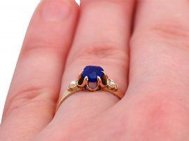 blue sapphire and pearl ring on hand