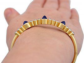 close up hand wearing sapphire bangle