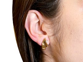 wearing diamond and gold earrings