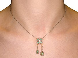 wearing emerald and diamond pendant