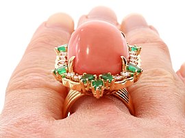 Coral Ring with Emeralds Being Worn on the Hand