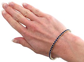 Sapphire tennis bracelet in gold wearing 